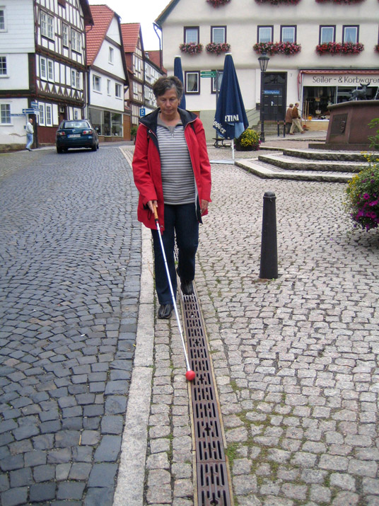 Mit dem Langstock durch die kopfsteingepflasterte Altstadt: Ein Ablaufrost dient als Leitlinie.